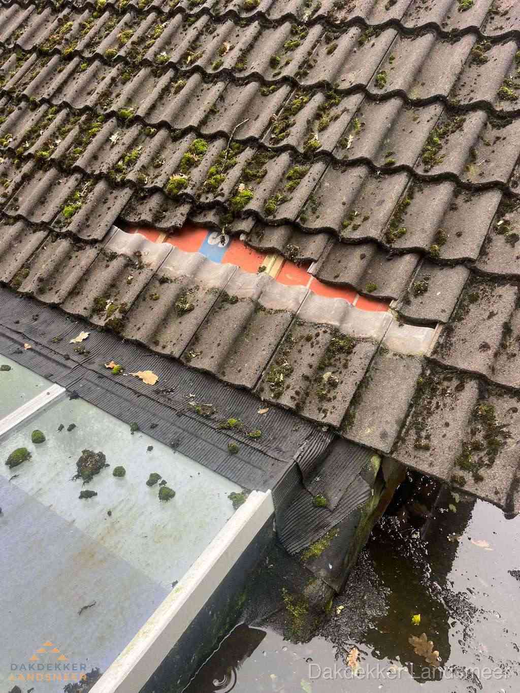 Beschadigd pannendak met ontbrekende dakpannen voor reparatie in Landsmeer