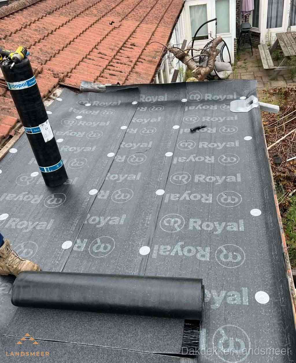Plat dak met nieuwe bitumen dakbedekking en brandgereedschap in Landsmeer