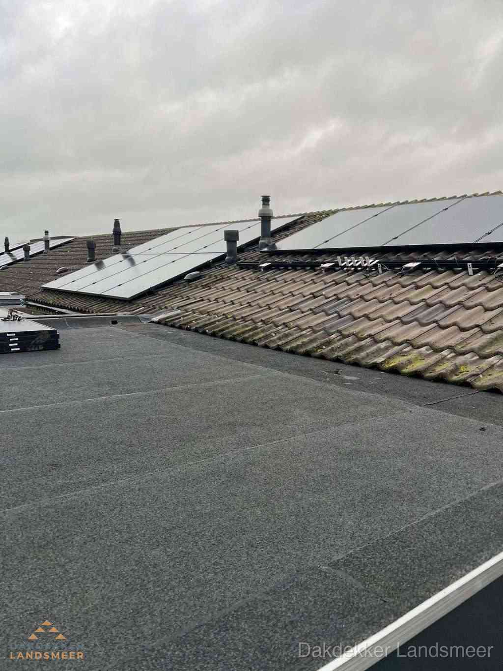 Plat dak inspectie met bitumen bedekking naast schuin pannendak in Landsmeer