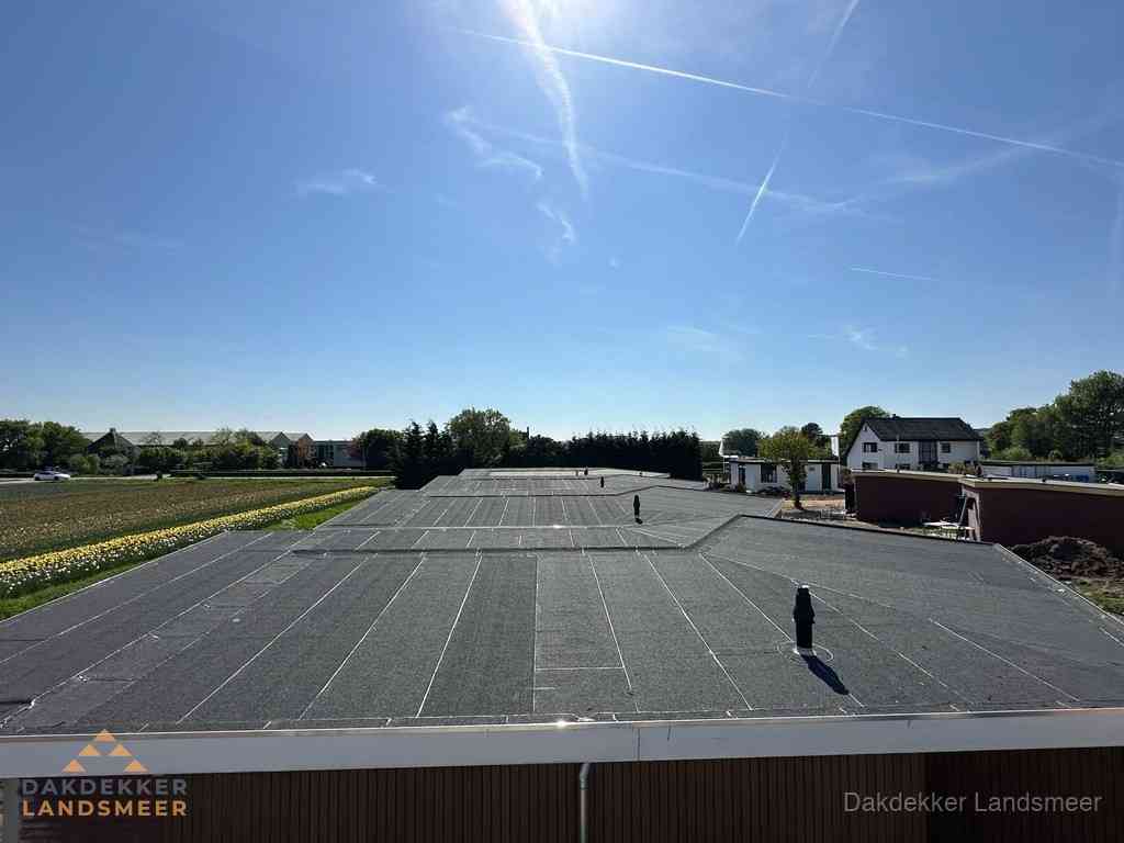 Groot plat dak met bitumen dakbedekking op bedrijfspand in Landsmeer
