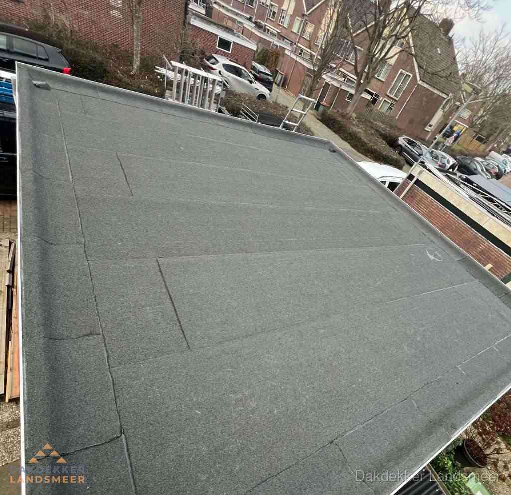 Nieuwe bitumen dakbedekking op plat dak van garage in Landsmeer
