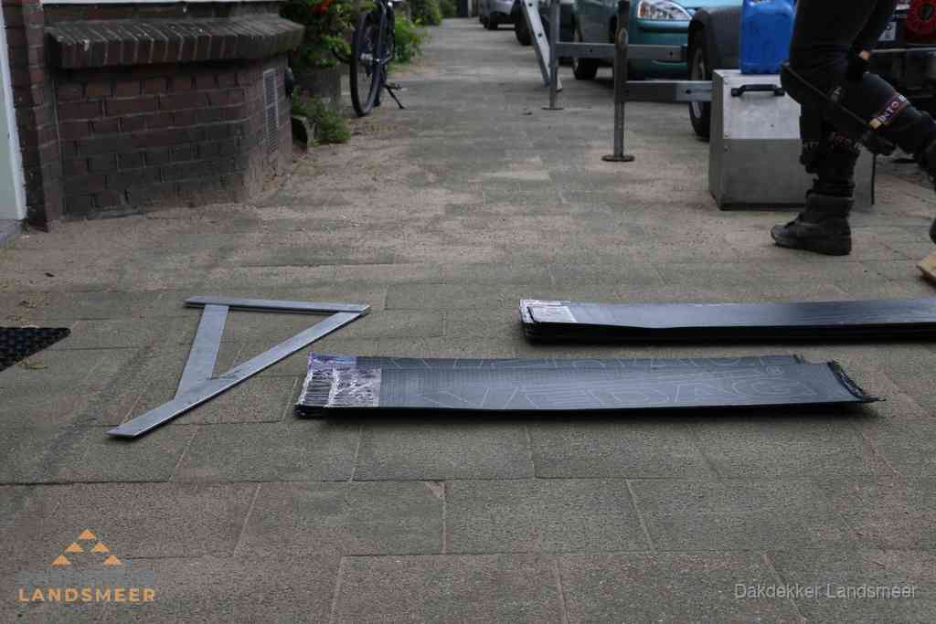 Dakbedekkingsmateriaal en zinkwerk klaargelegd voor reparatie in Landsmeer