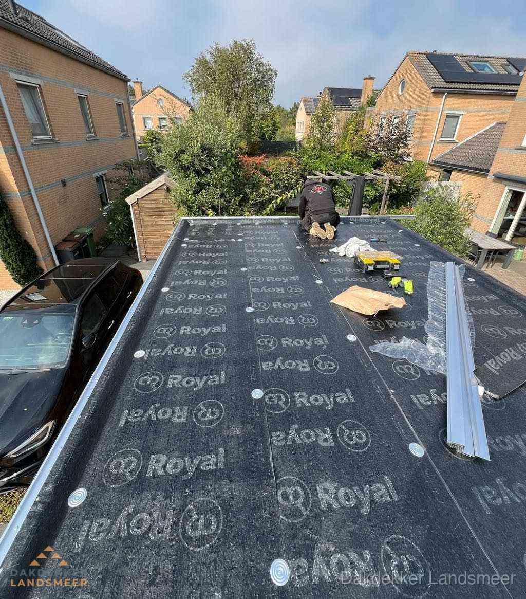Dakdekker aan het werk op plat dak renovatie in Landsmeer