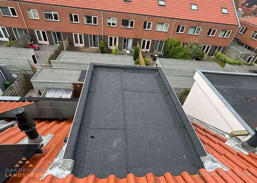 Plat dak met bitumen bedekking naast dakkapel in Landsmeer