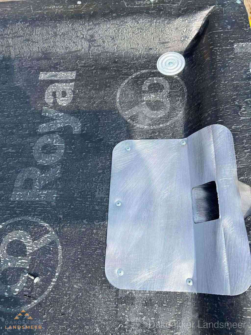Dakdoorvoer met metalen afvoerplaat op bitumen dak in Landsmeer