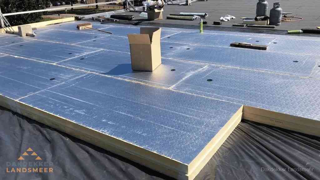 PIR isolatieplaten worden gelegd op plat dak voor dakisolatie in Landsmeer