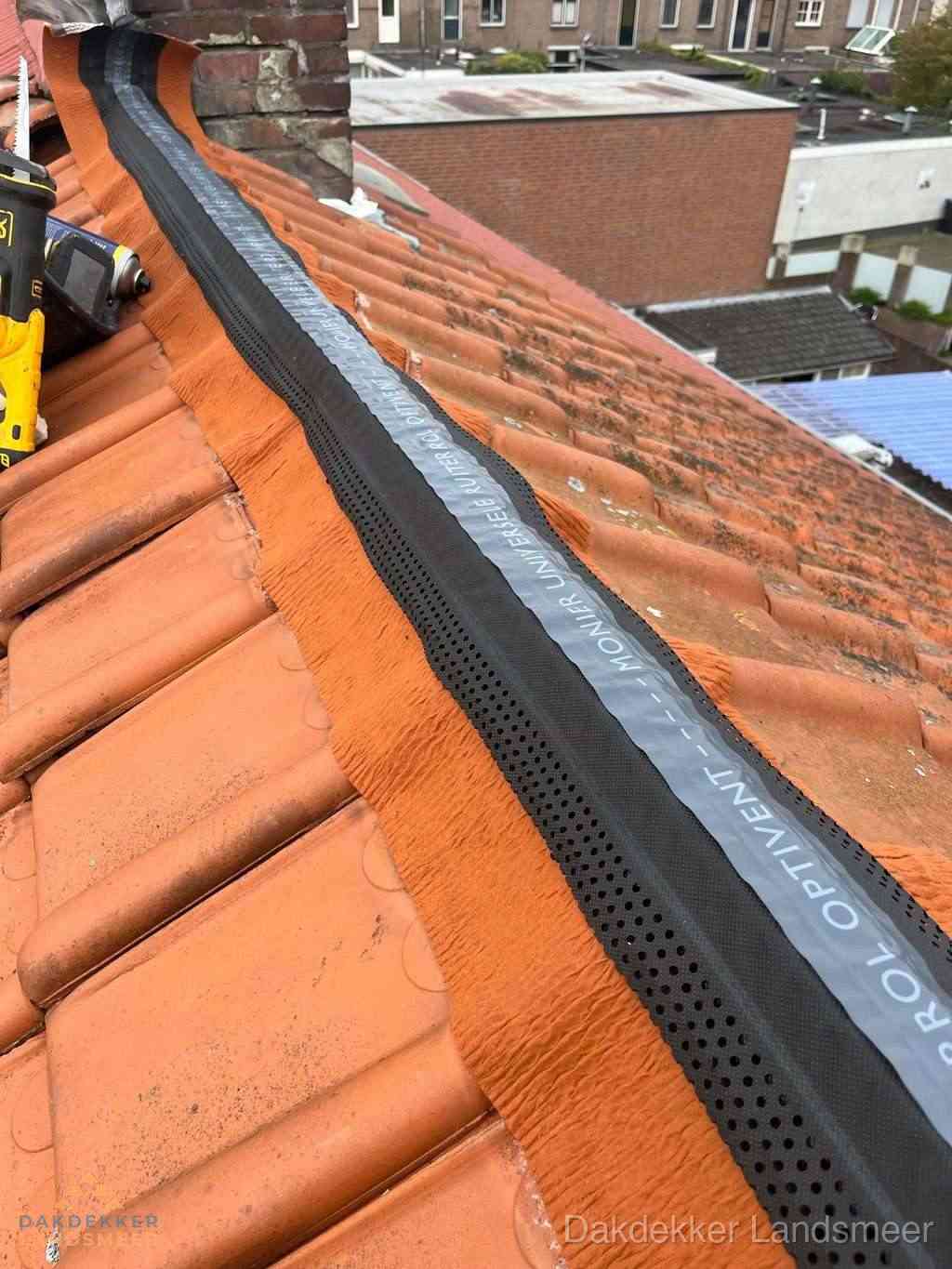 Plat dak aanbouw met bitumen naast schuin pannendak in Landsmeer