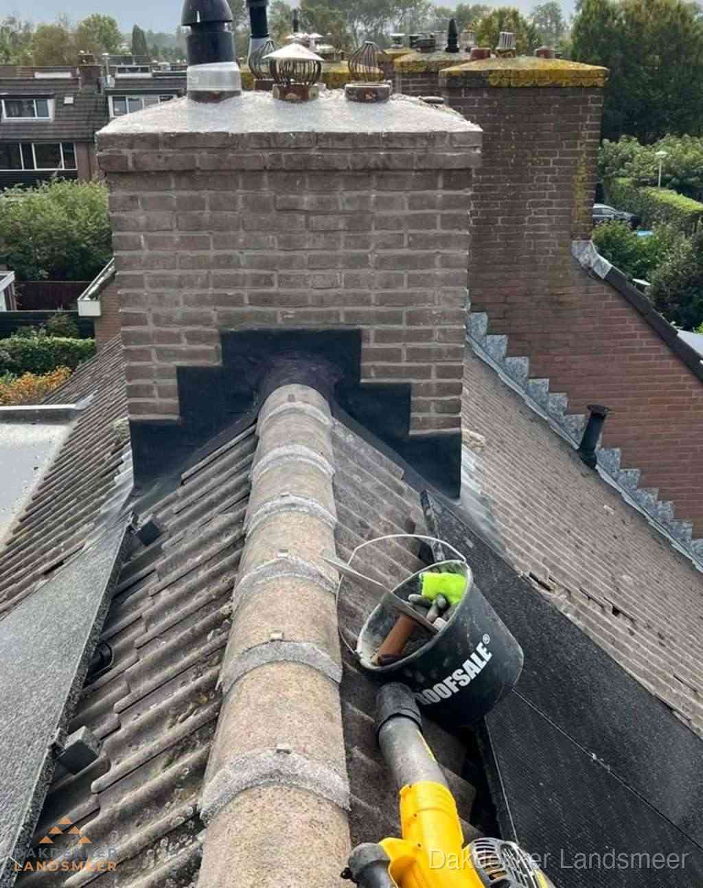 Dakdekker repareert bitumen dakleer bij dakdoorvoer in Landsmeer